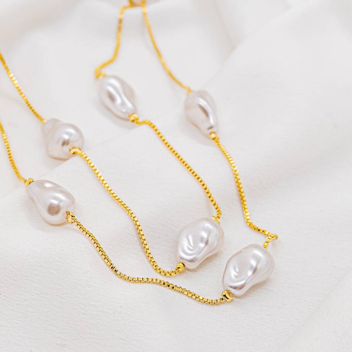 Long gold necklace with fine Venetian chain, adorned with irregular pearly white baroque pearls