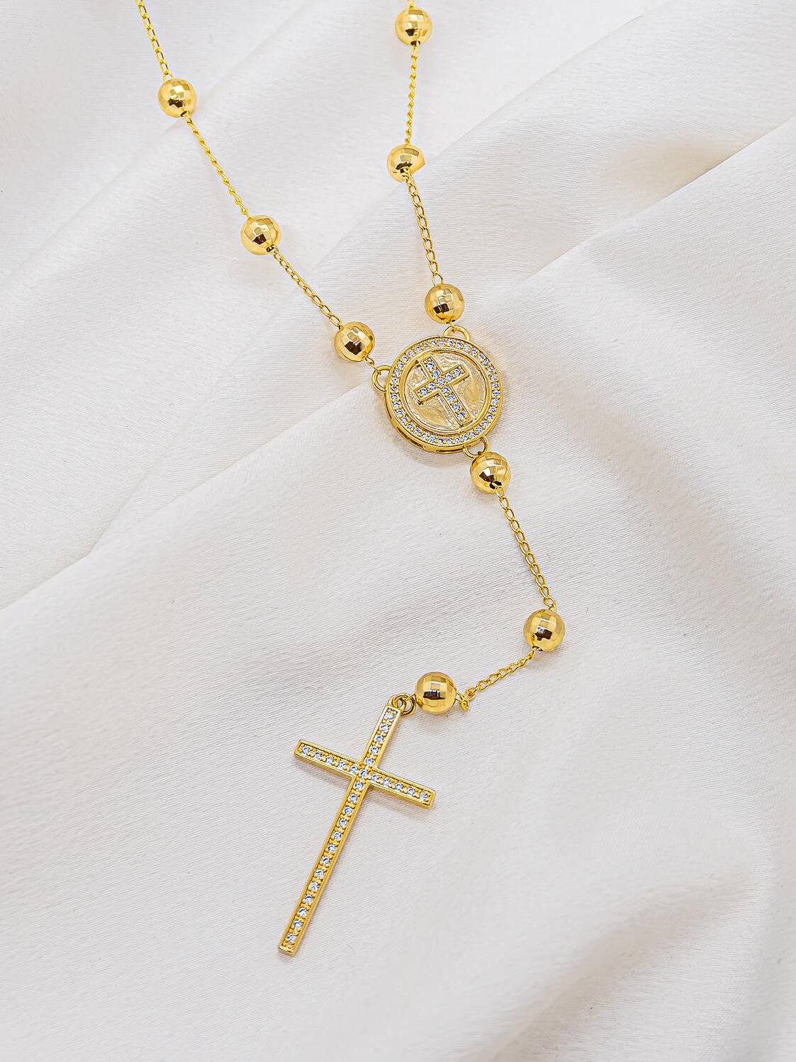 Collier long de boules dorées facettées, médaille ronde à croix sertie et grande croix