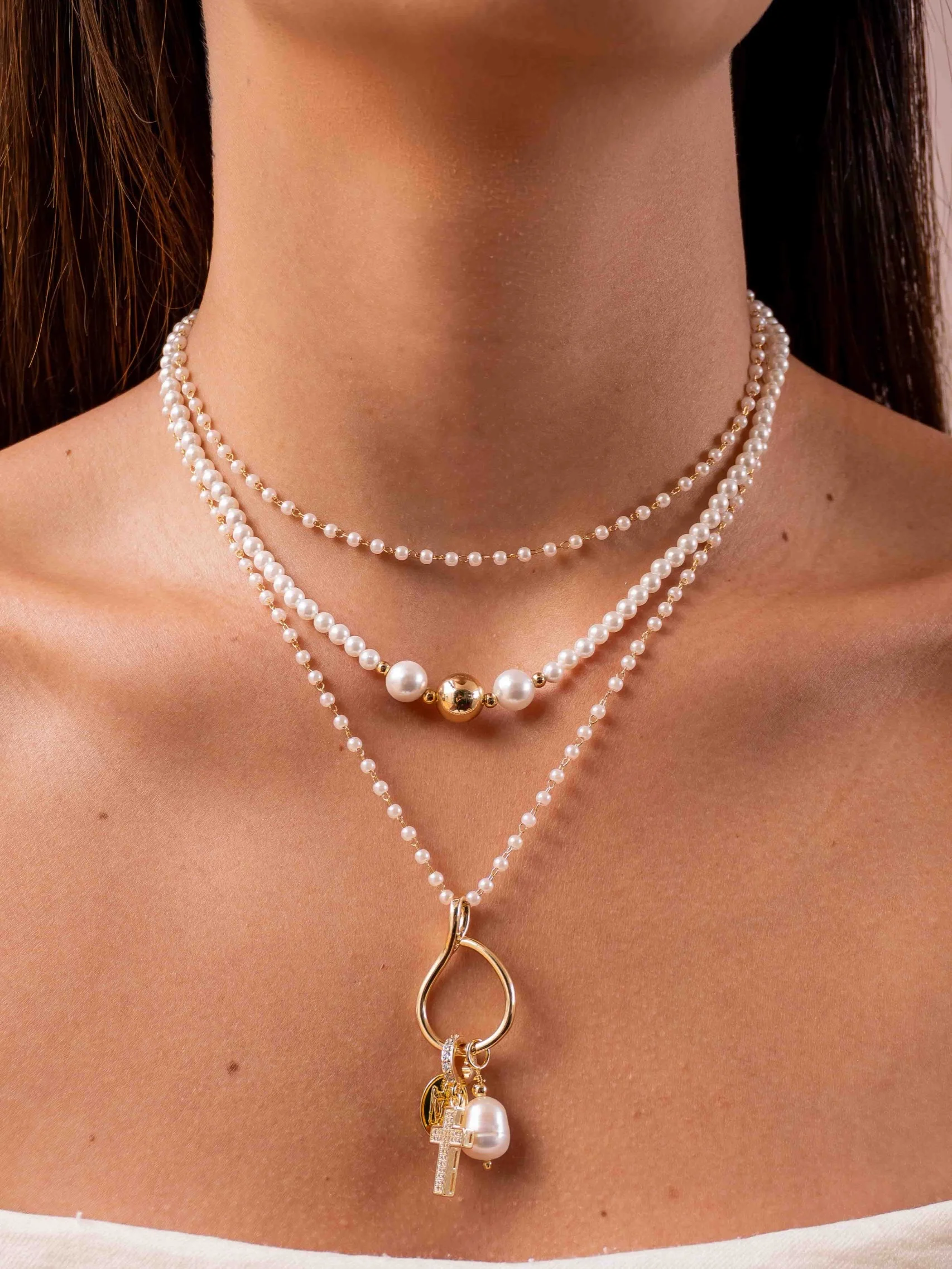 Long necklace, small pearls and religious charms, worn close-up