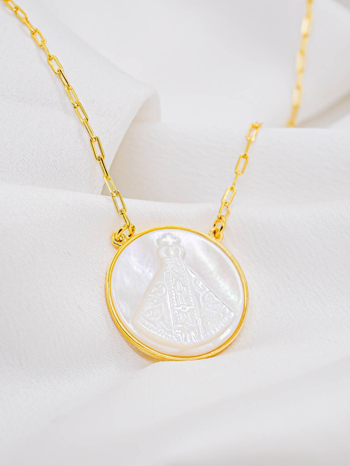 Pendentif rond en nacre avec Vierge couronnée gravée et cadre doré, sur chaîne à mailles allongées
