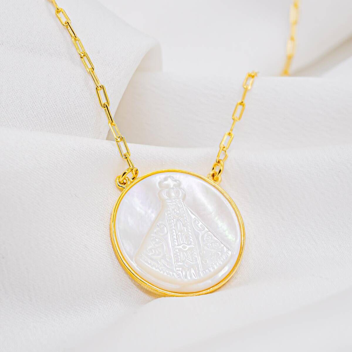 Round mother-of-pearl pendant with engraved crowned Virgin and gold-toned frame, on an elongated-link chain