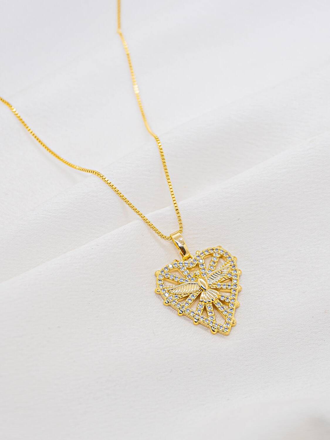 Collier doré à pendentif en cœur ajouré, colombe centrale et contour serti de pierres claires
