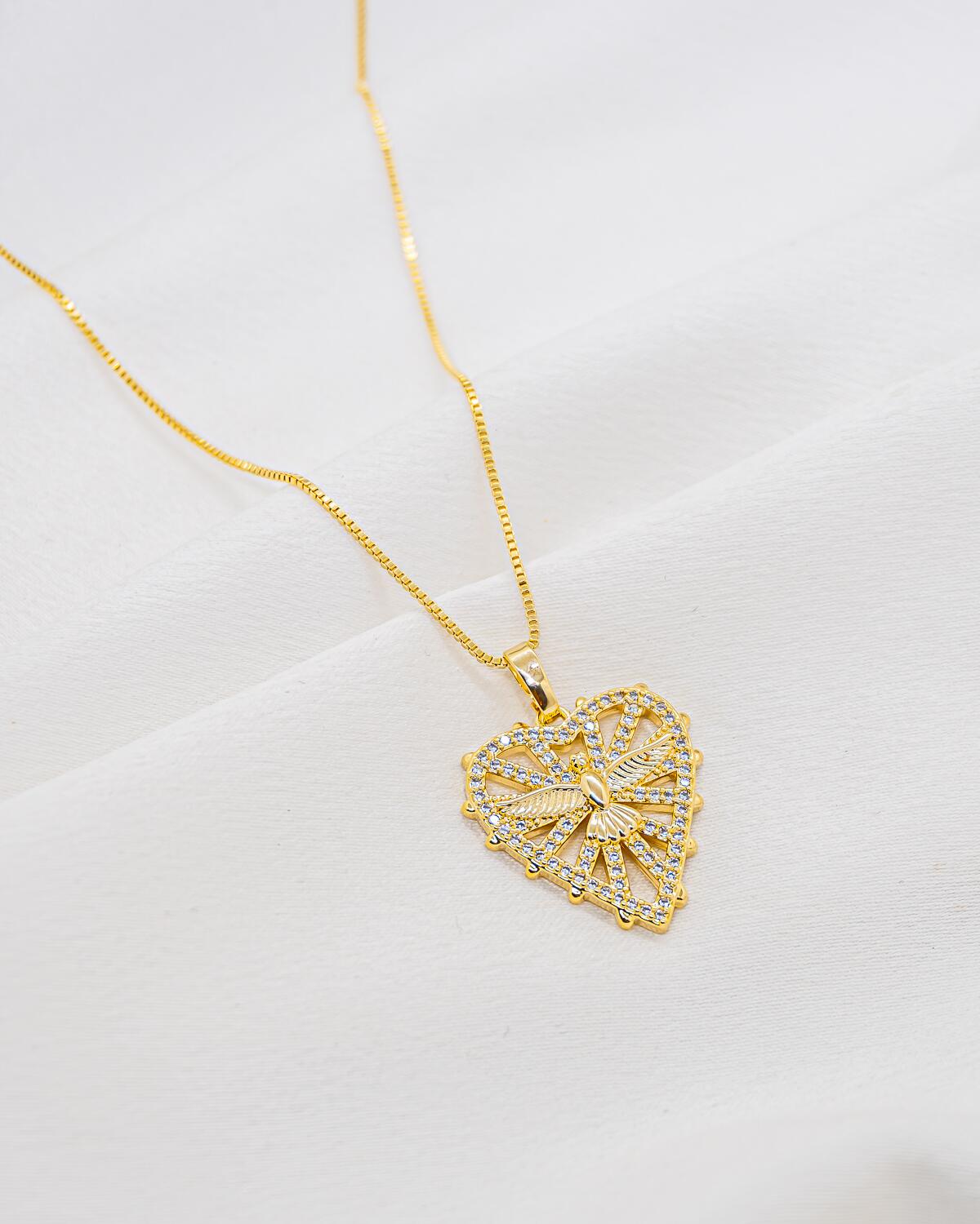 Gold necklace with openwork heart pendant, central dove, and border set with clear stones