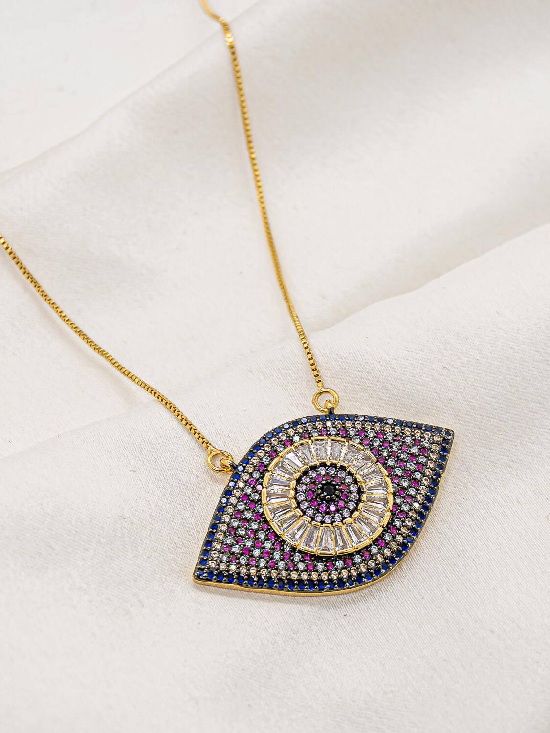 Collier doré à grand pendentif œil grec serti de pierres bleues, roses et claires