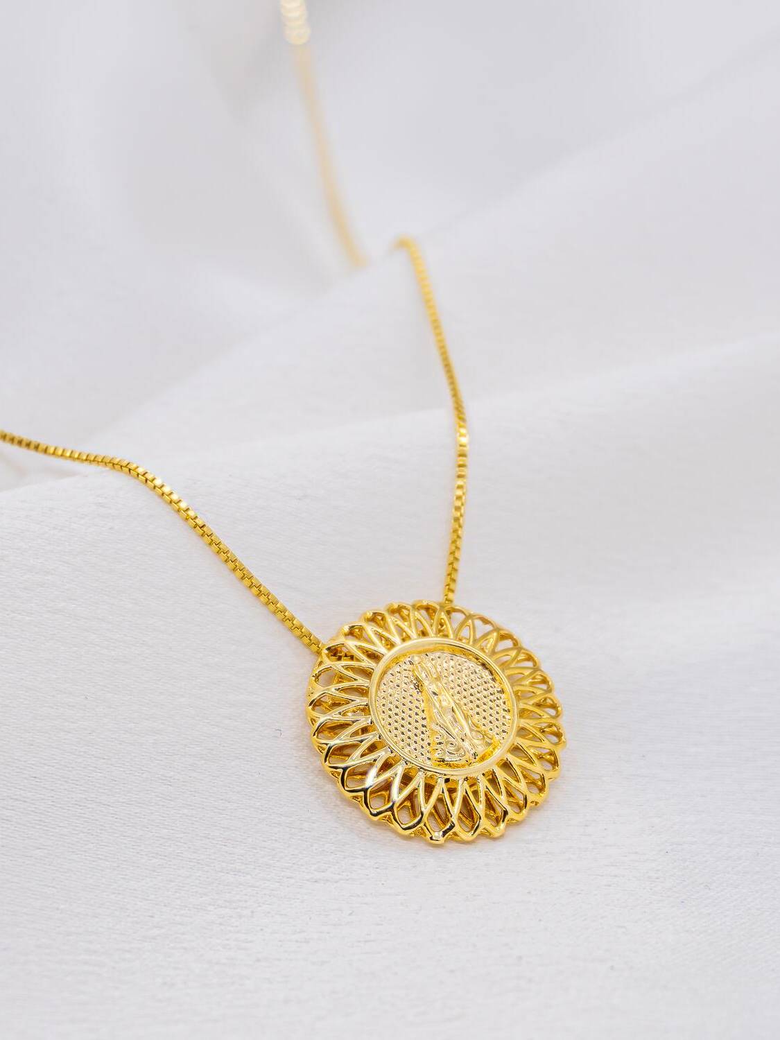 Collier doré à fine chaîne et médaillon rond ajouré aux pétales, Vierge en relief au centre