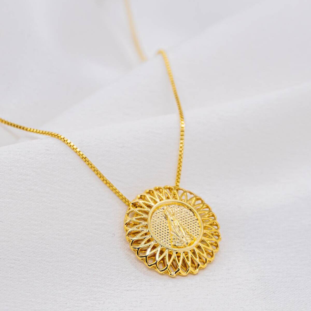 Golden necklace with fine chain and openwork round medallion with petal details, relief Virgin at center