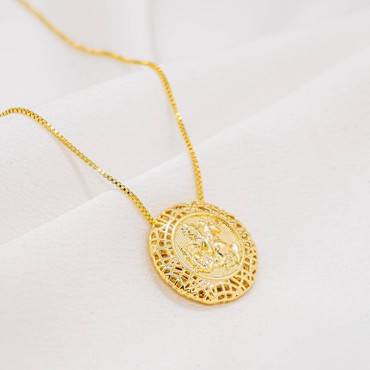 Gold necklace with round medallion showing relief rider with lance, filigree frame