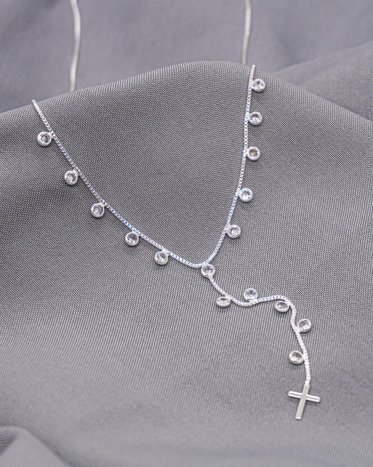 Collier argenté à maille vénitienne, petites pierres claires pendantes, chute en Y et croix lisse