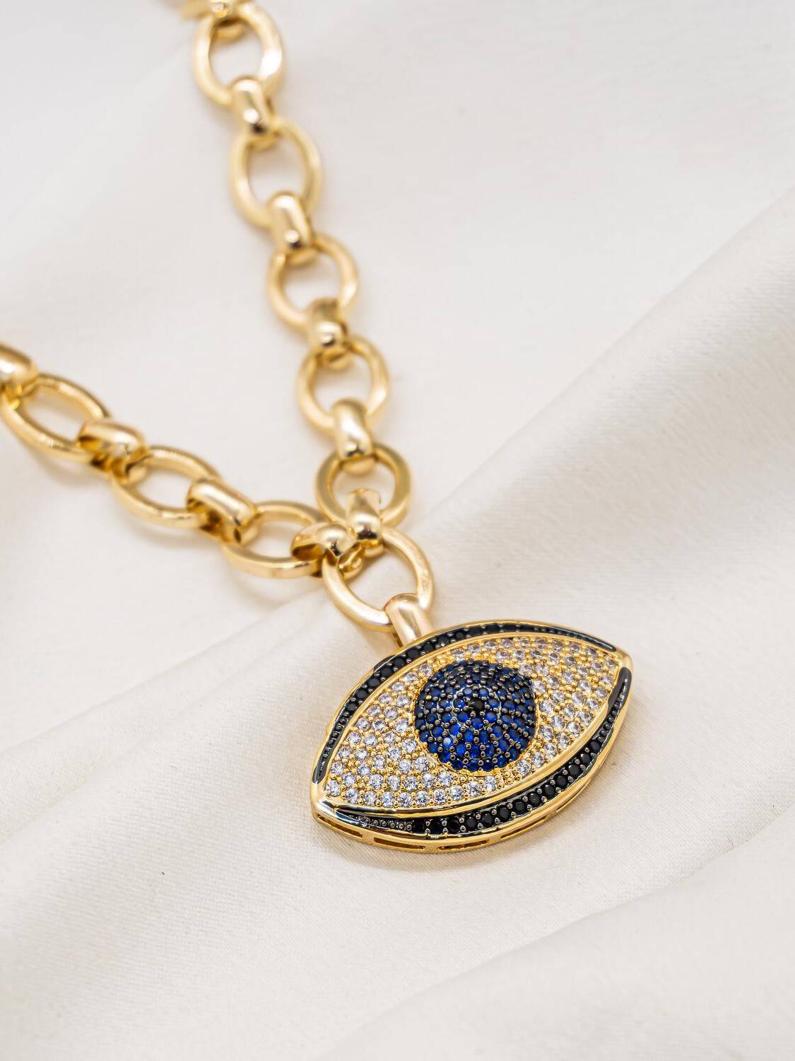 Collier doré à larges maillons ovales et pendentif œil grec serti, iris bleu