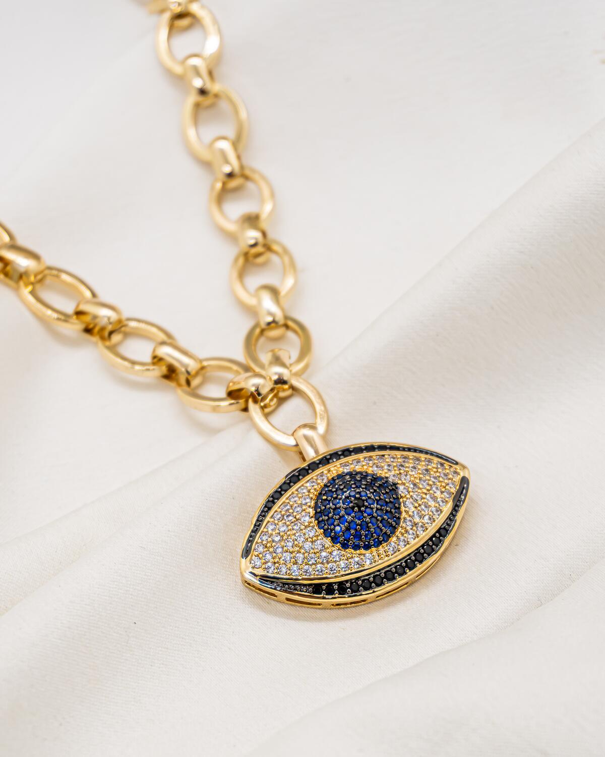 Collier doré à larges maillons ovales et pendentif œil grec serti, iris bleu