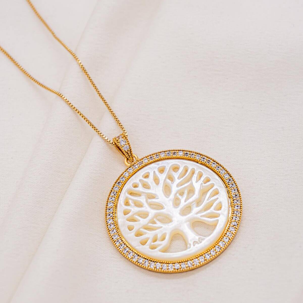 Gold-toned necklace, round Tree of Life openwork mother-of-pearl medallion, pavé-set clear-stone border
