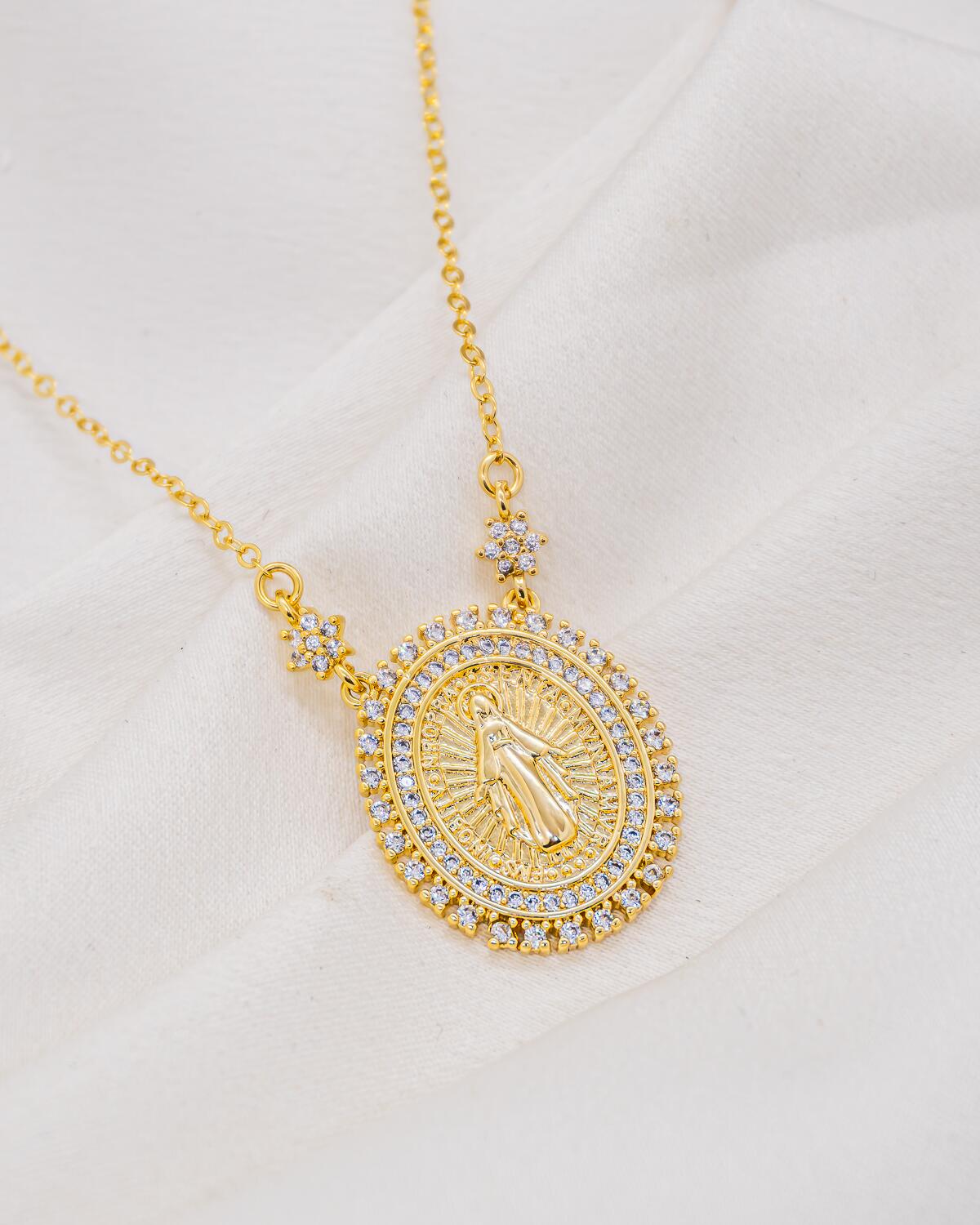 Collier doré à médaille ovale de la Vierge, bordure de pierres claires et deux fleurs serties