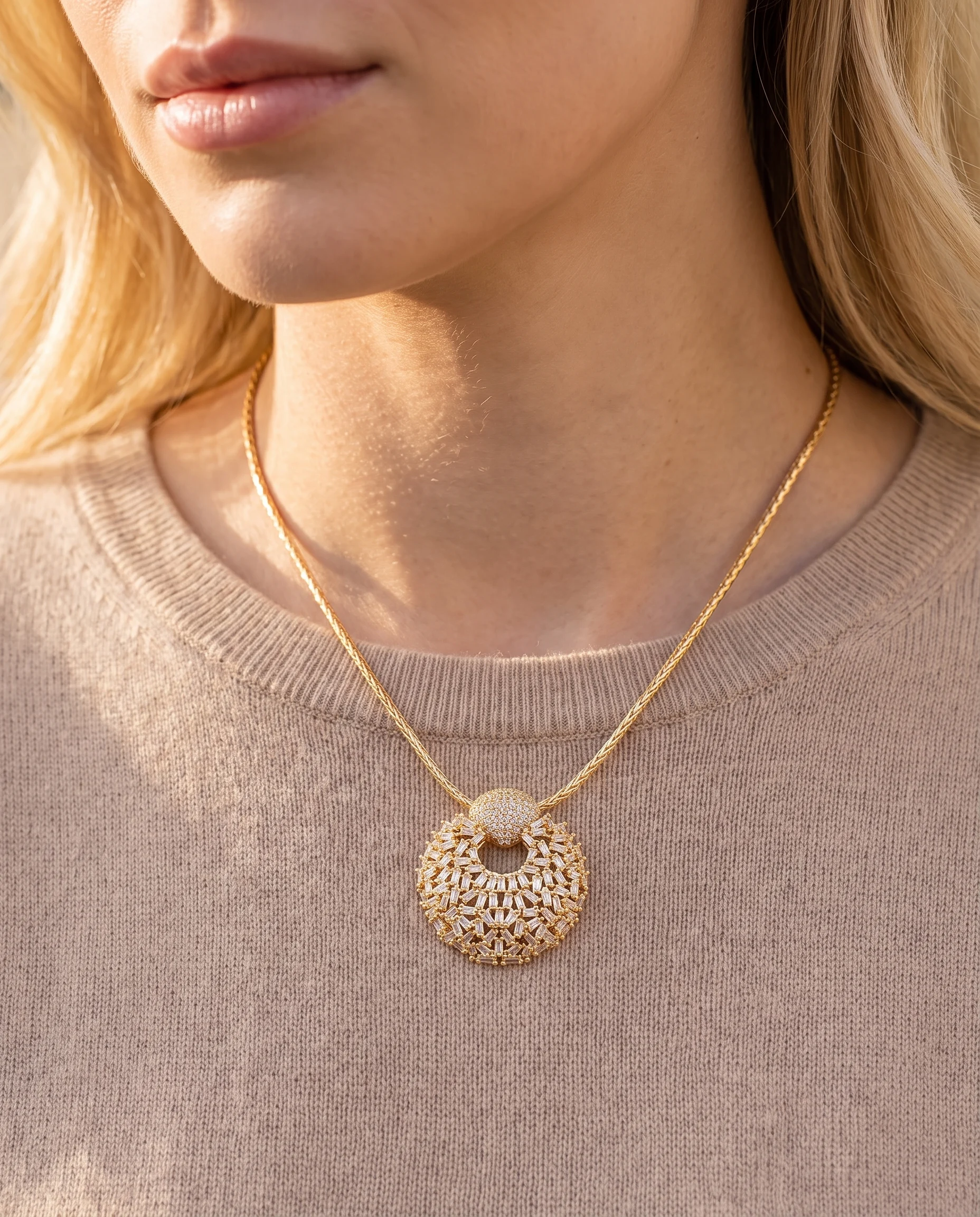 Collier doré à pendentif rond bombé serti de zircons baguette, porté sur la poitrine, vu de près