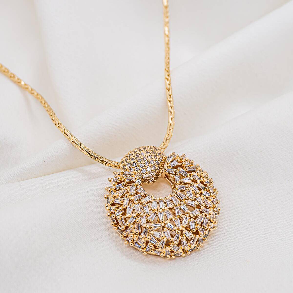 Gold necklace with large openwork round pendant covered in baguette-cut zircons, domed pavé-set bail