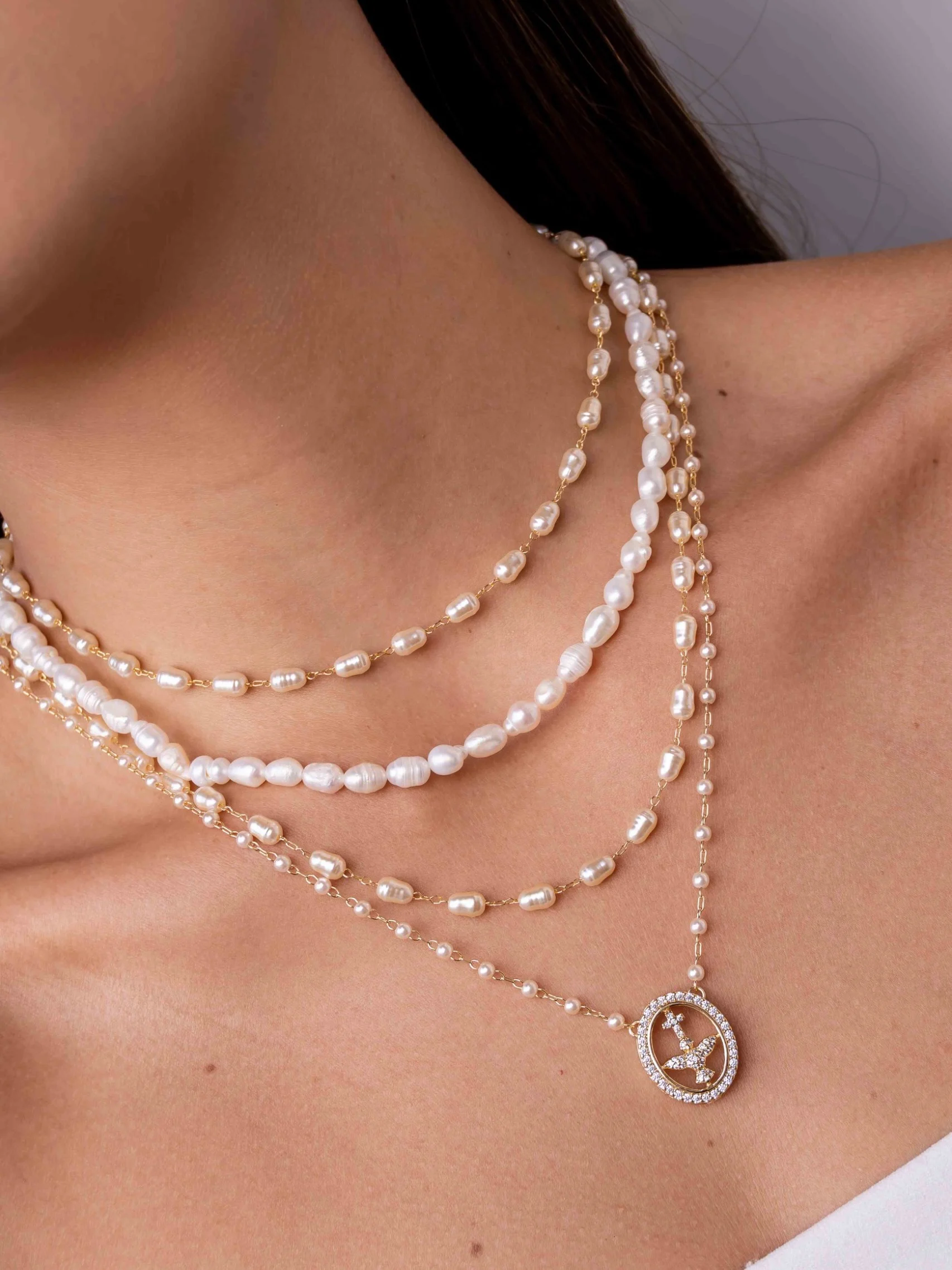 Collier petites perles, médaille ovale Saint-Esprit sertie, porté en gros plan, autre vue