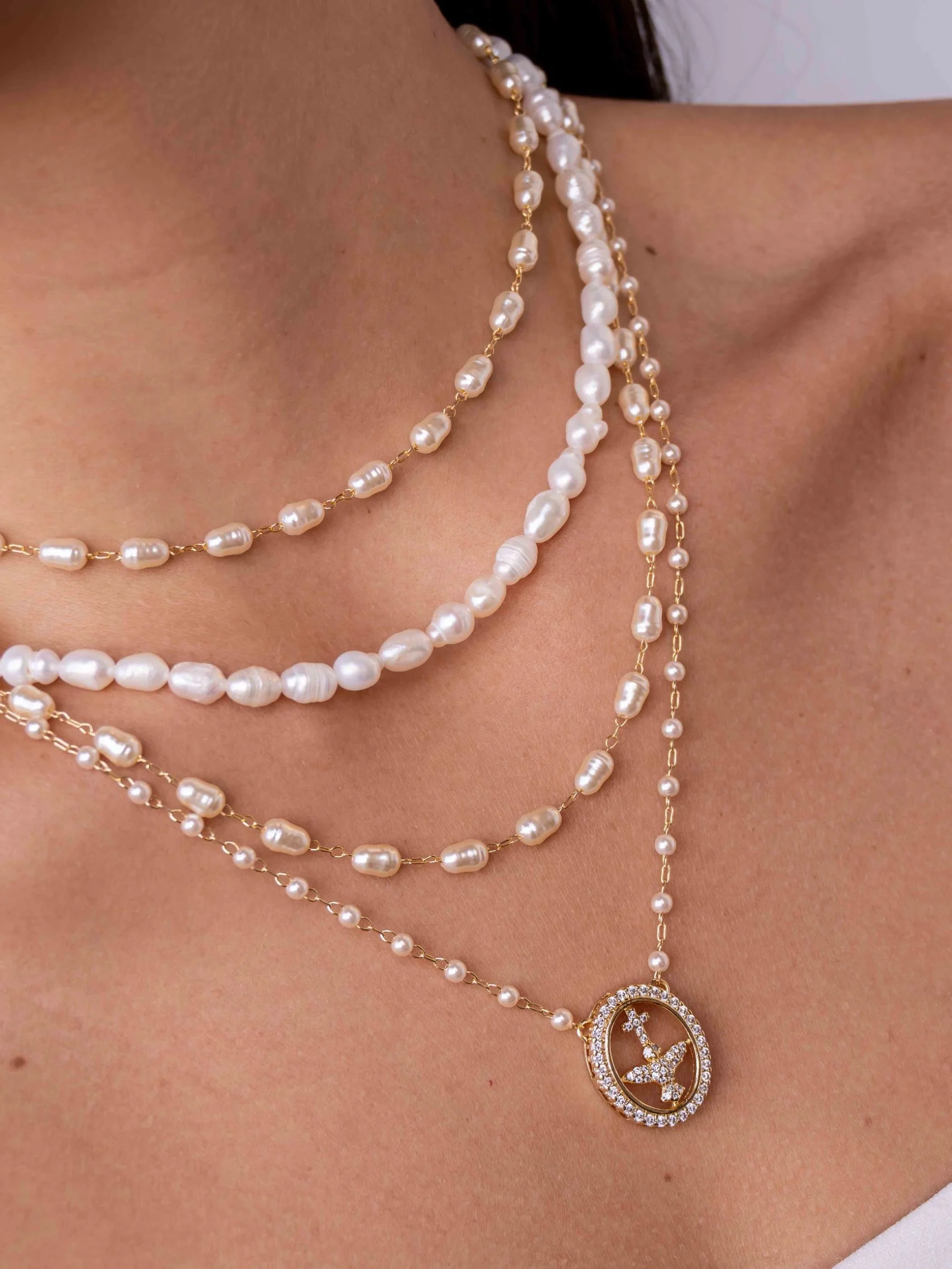 Collier petites perles, médaille ovale Saint-Esprit sertie, porté en gros plan