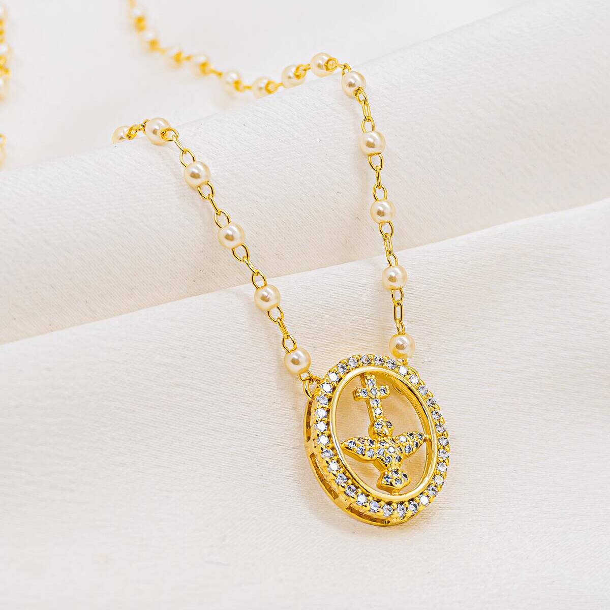 Small white pearl and gold link necklace, pavé-set oval medal with dove and cross