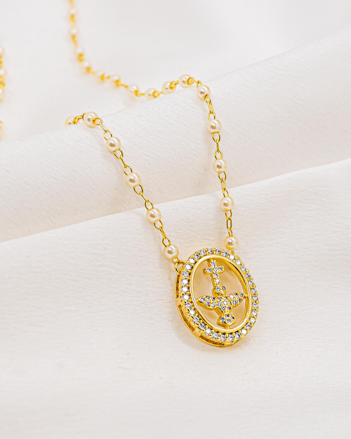 Collier de petites perles blanches et maillons dorés, médaille ovale sertie avec colombe et croix