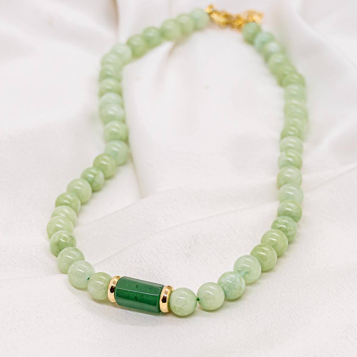 Green stone round-bead necklace with dark green cylindrical center piece and gold rings