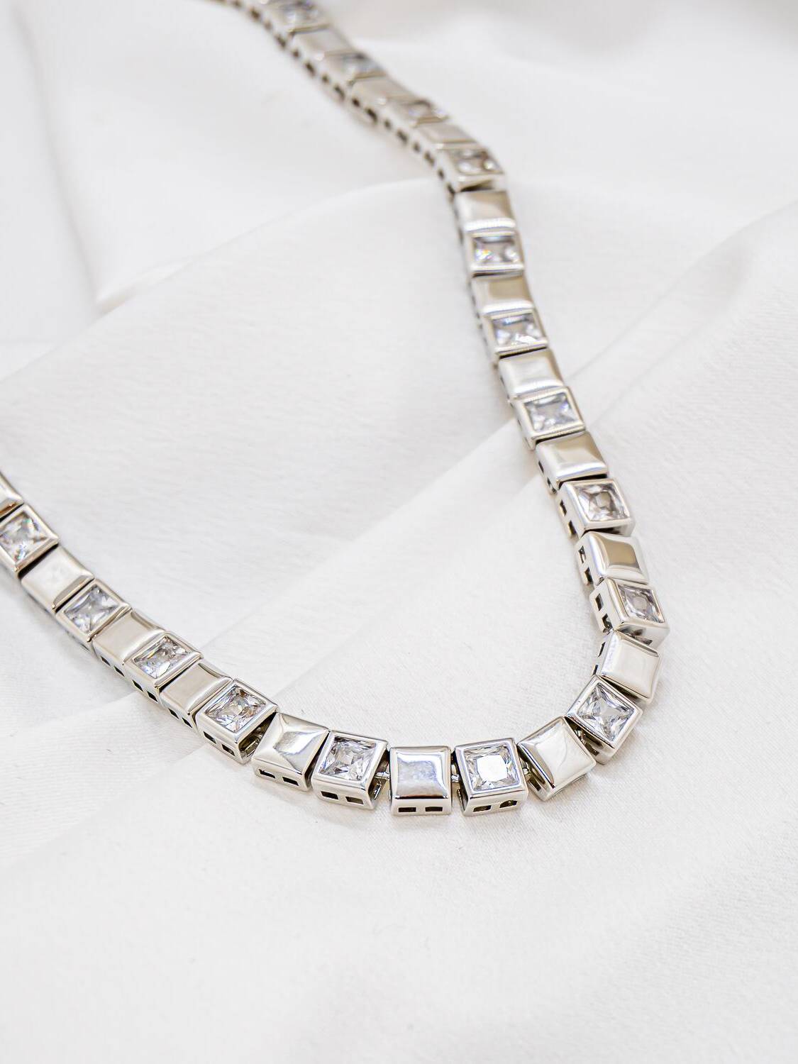 Collier ras-de-cou argenté alternant carrés de métal poli et pierres claires carrées serties