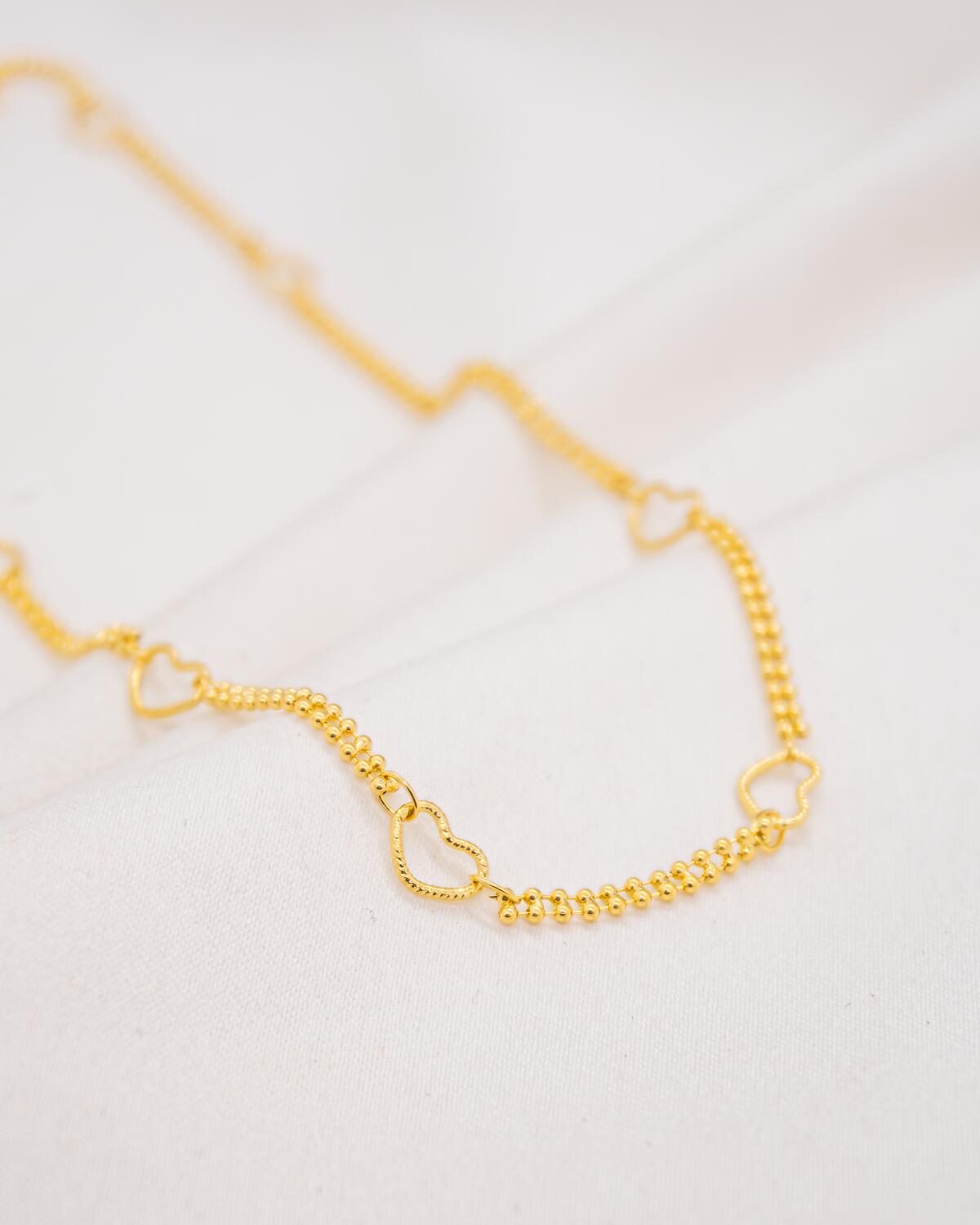 Gold-plated choker with small bead chain punctuated by textured openwork hearts