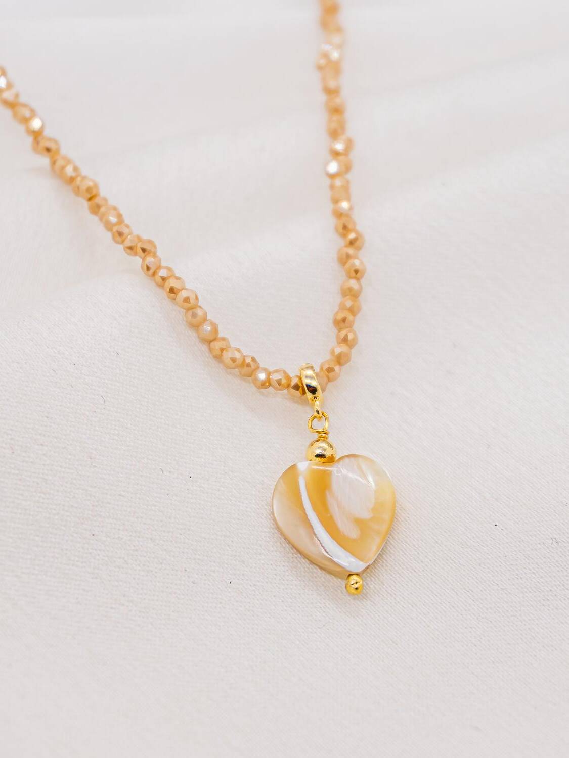 Ras-de-cou de cristaux beiges facettés avec pendentif cœur en nacre miel et ivoire