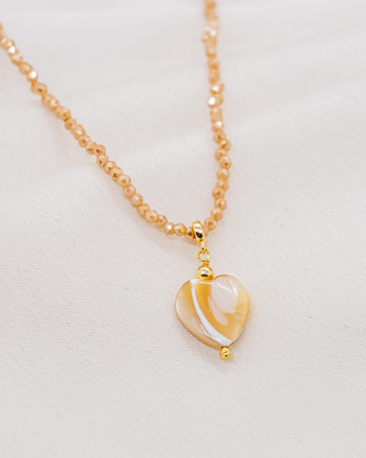 Choker de cristais bege facetados com pingente de coração de madrepérola mel e marfim