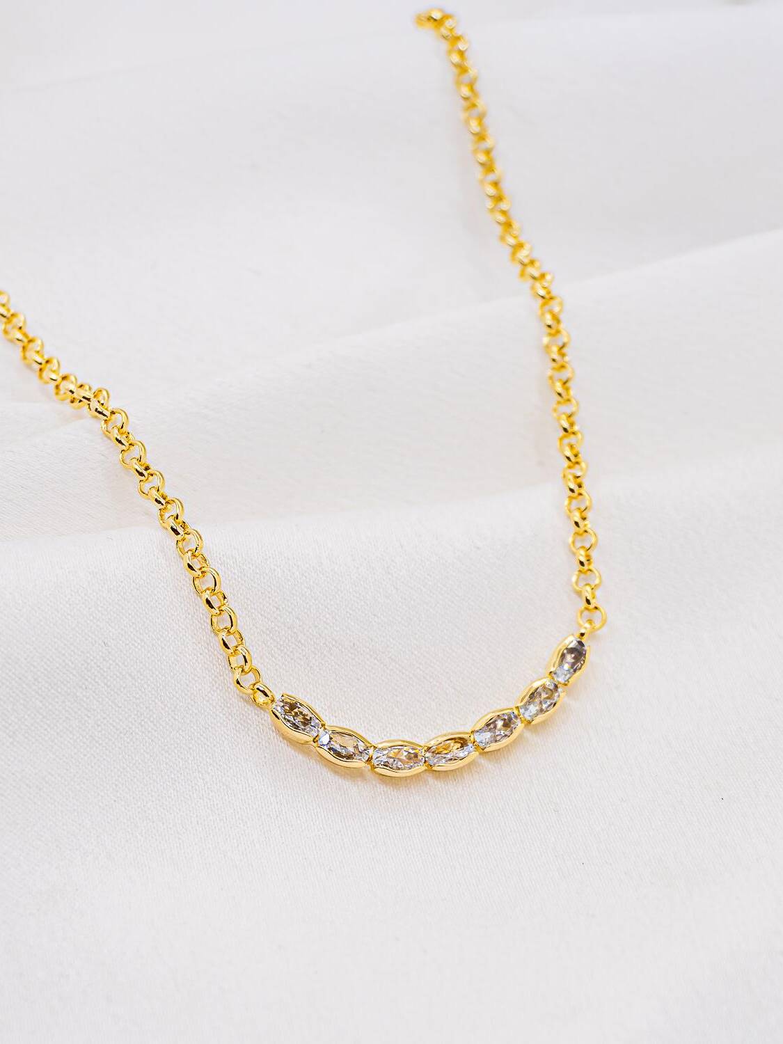 Collier ras-de-cou doré à petits maillons ronds, avec une suite de zircons ovales au centre