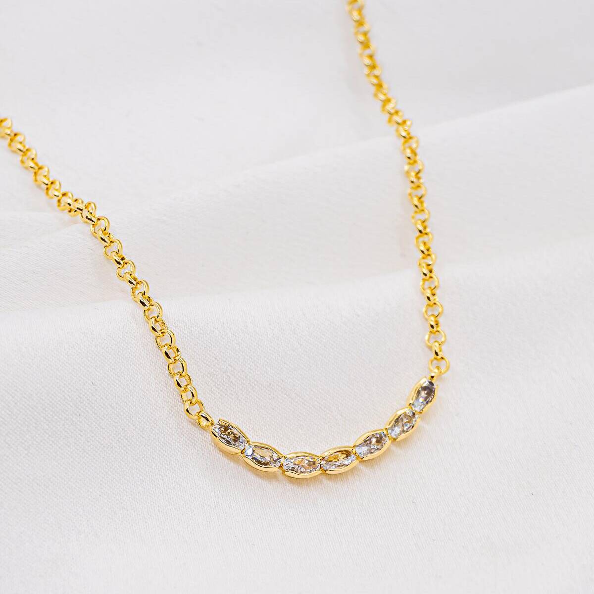 Gold choker necklace with small round links, featuring a row of oval zircons at the center