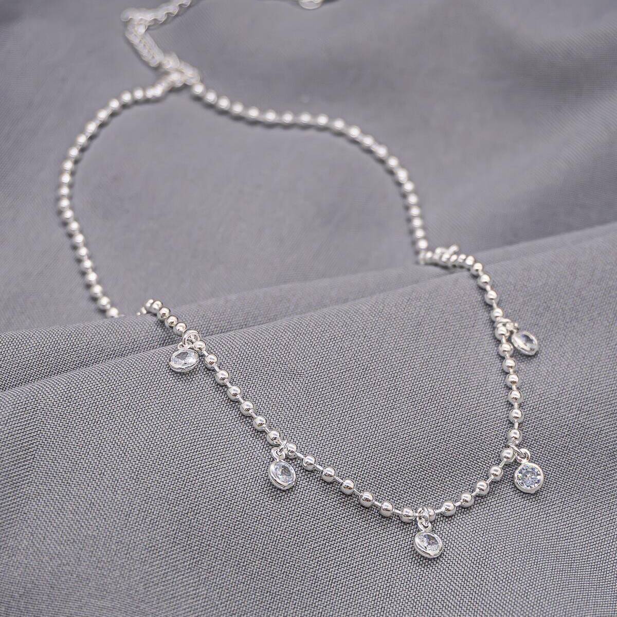 Silver beaded choker with clear set stones hanging at center