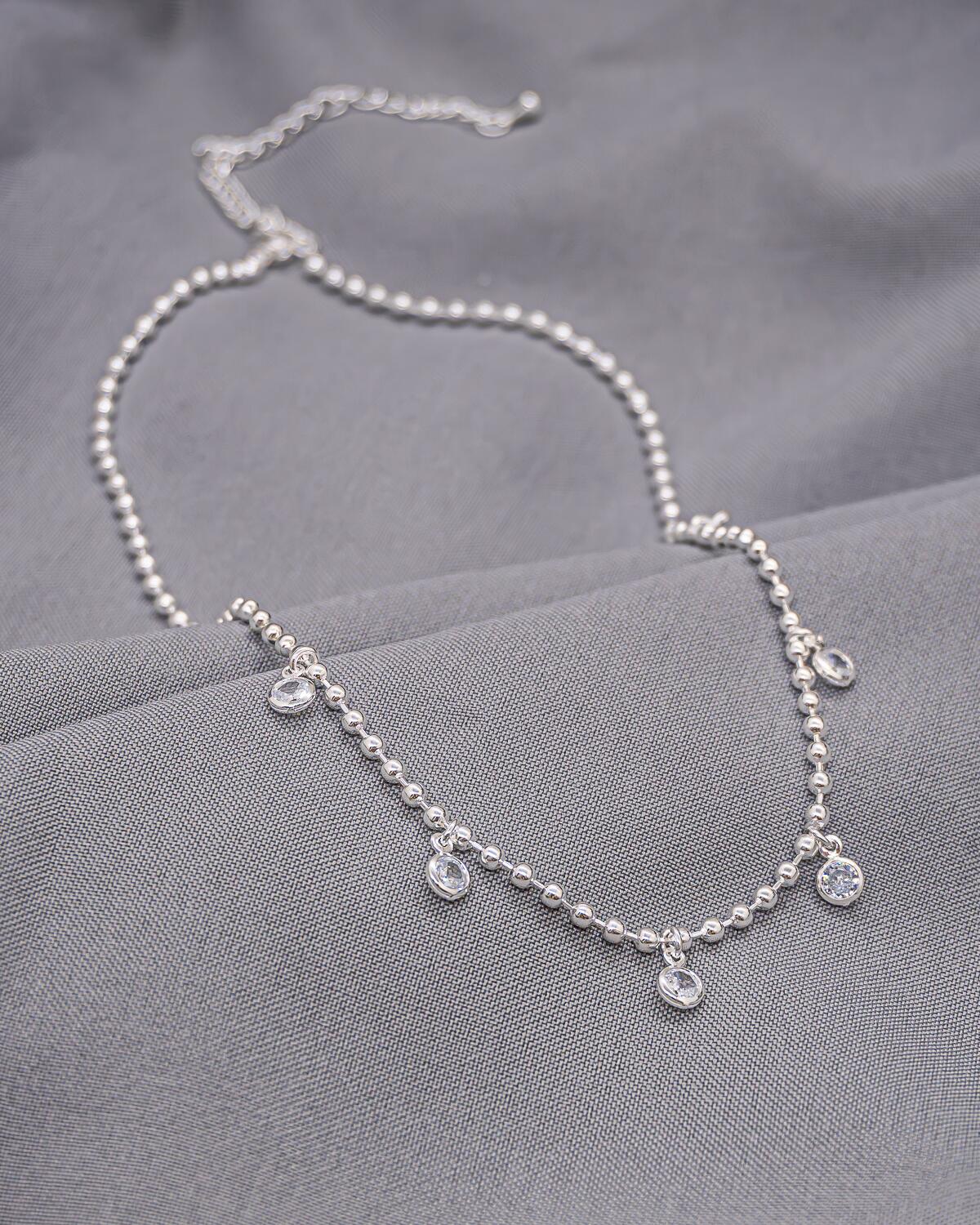 Silver beaded choker with clear set stones hanging at center
