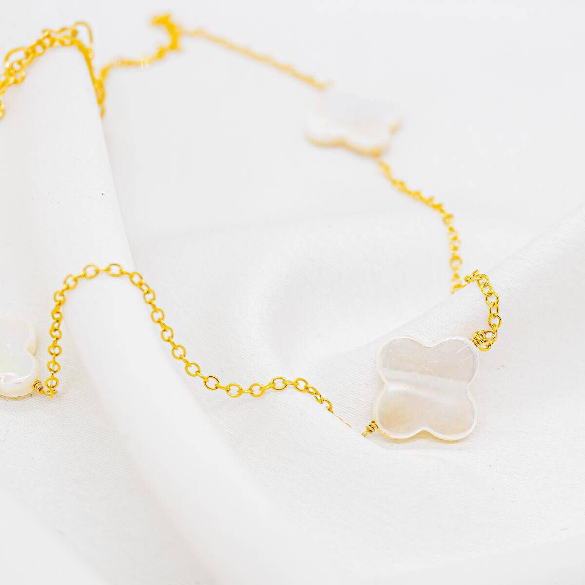 Golden fine-chain choker with white mother-of-pearl four-leaf clovers
