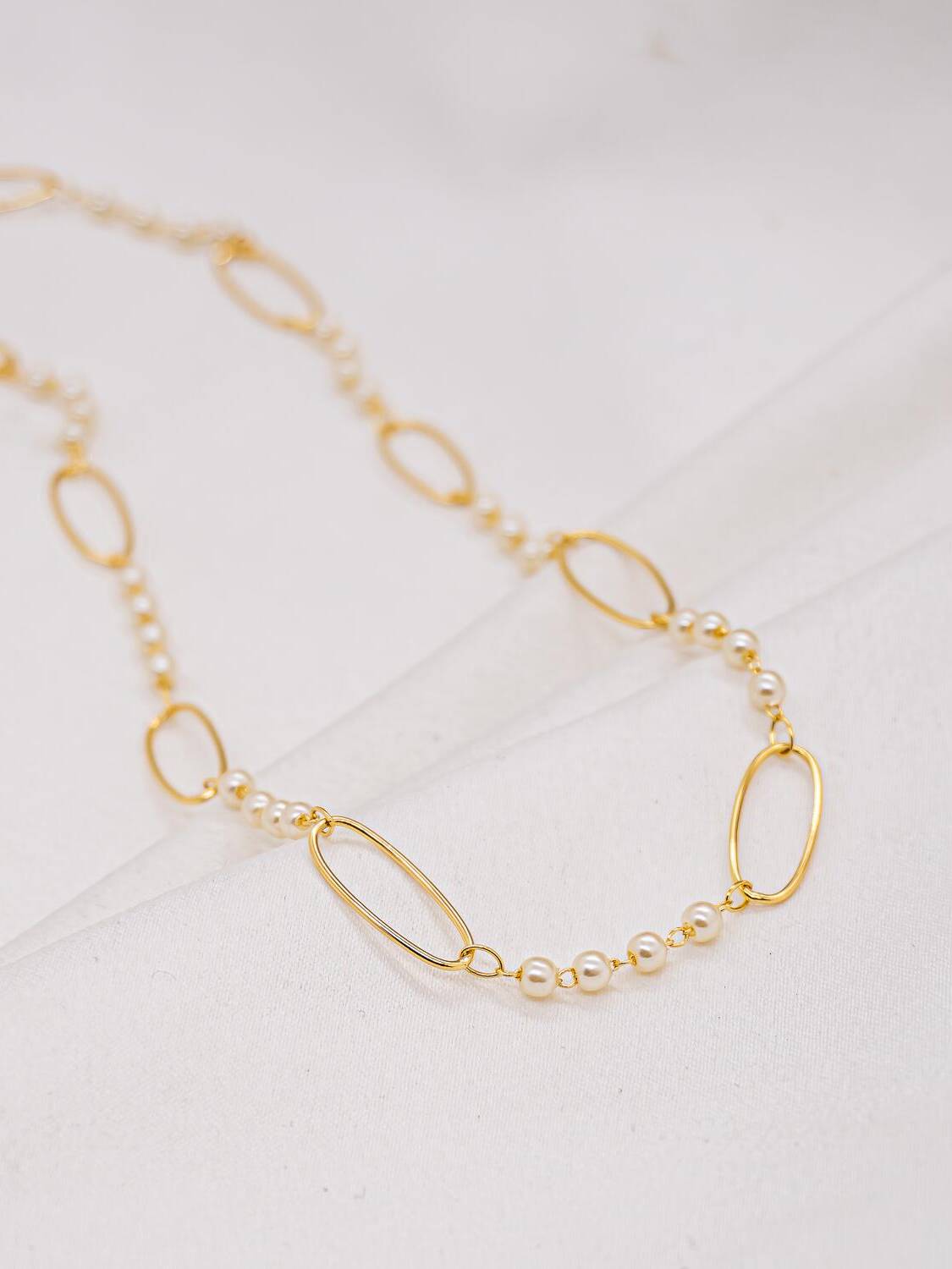 Collier doré à petits groupes de perles blanches entre de grands maillons ovales ouverts