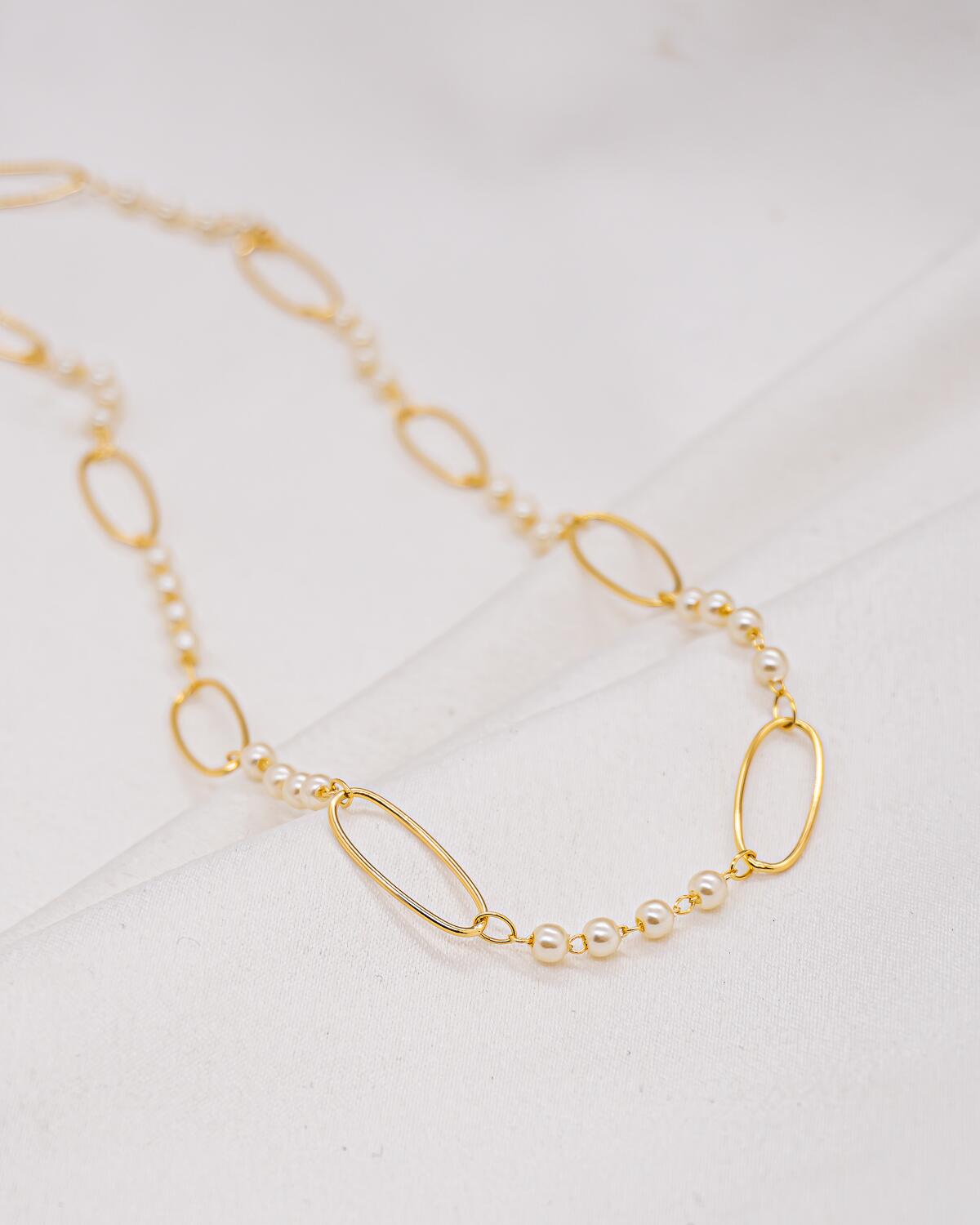Collier doré à petits groupes de perles blanches entre de grands maillons ovales ouverts