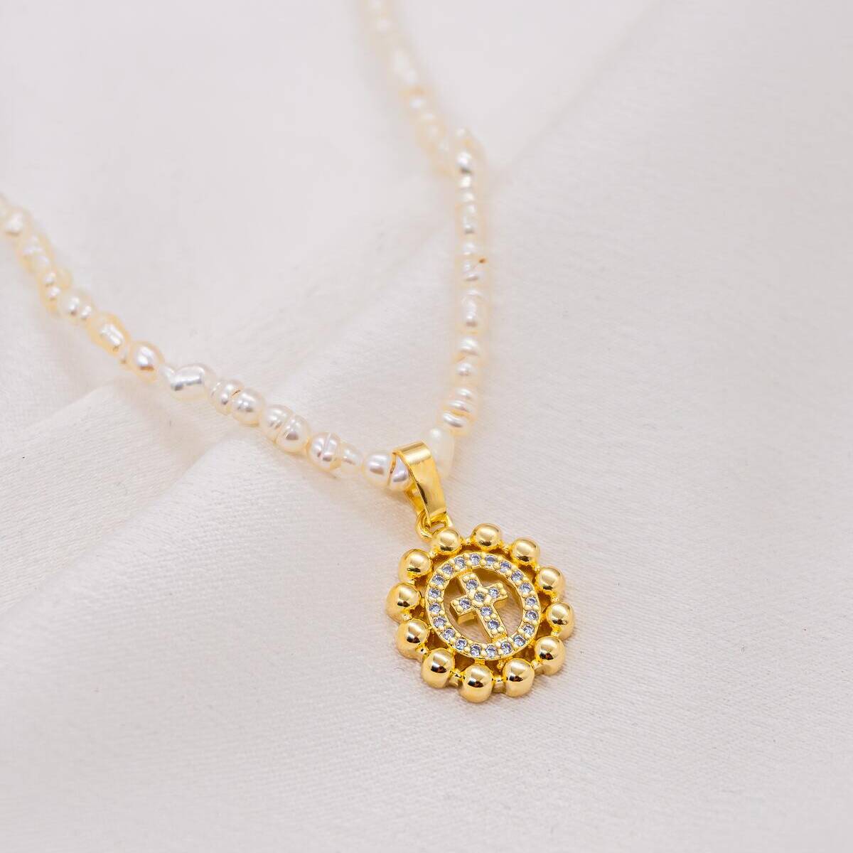 Irregular freshwater pearl choker with small gold round medallion and pavé-set cross in clear stones