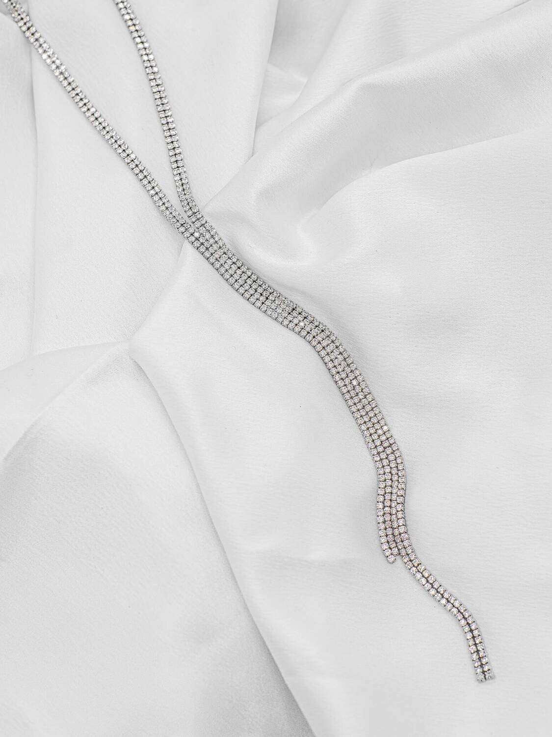 Long collier rivière argenté en rangées de pierres claires serrées, extrémités retombant en cascade