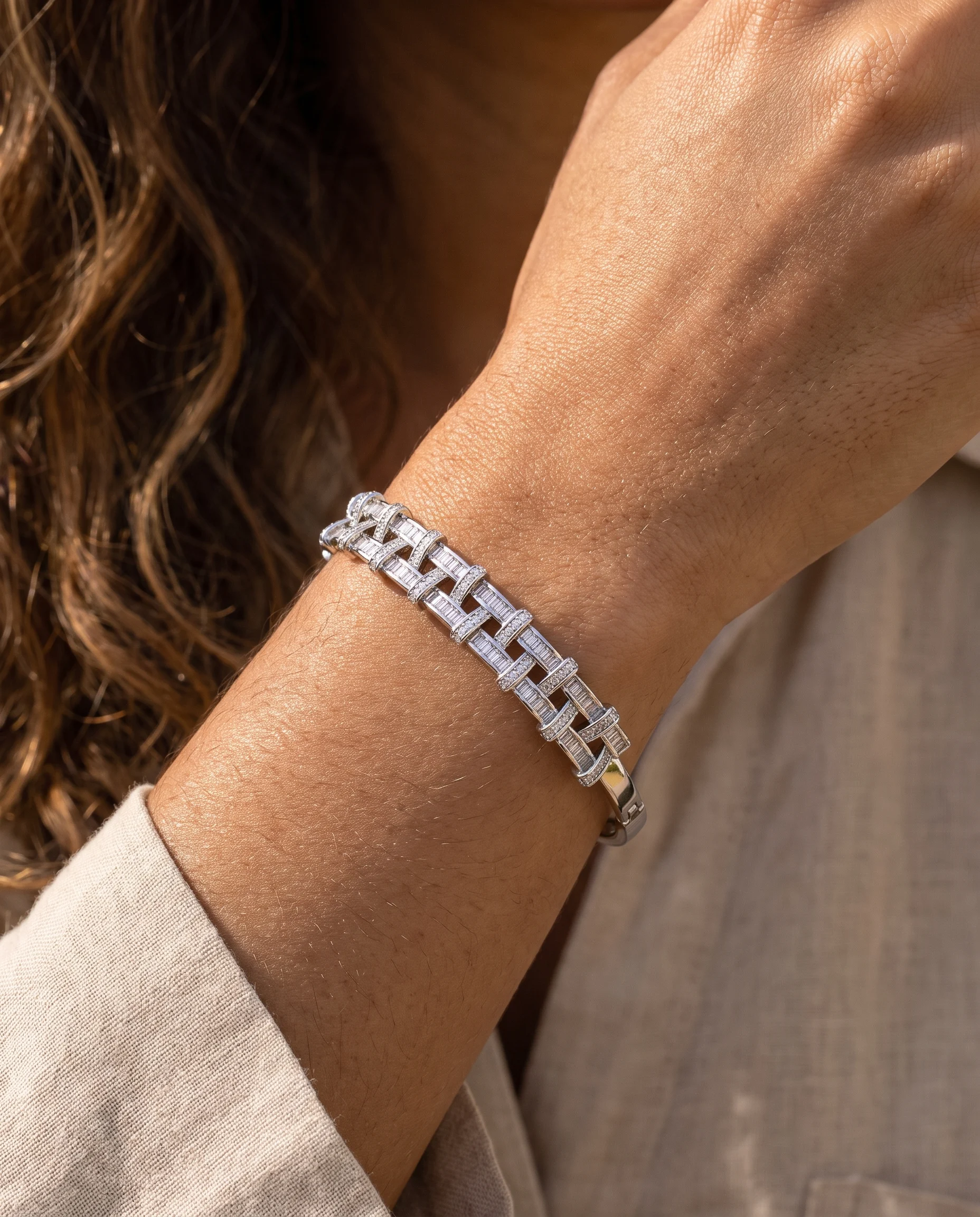 Jonc anneau entrelacé ajouré serti zircons baguette rhodium blanc, porté au poignet, vu de près