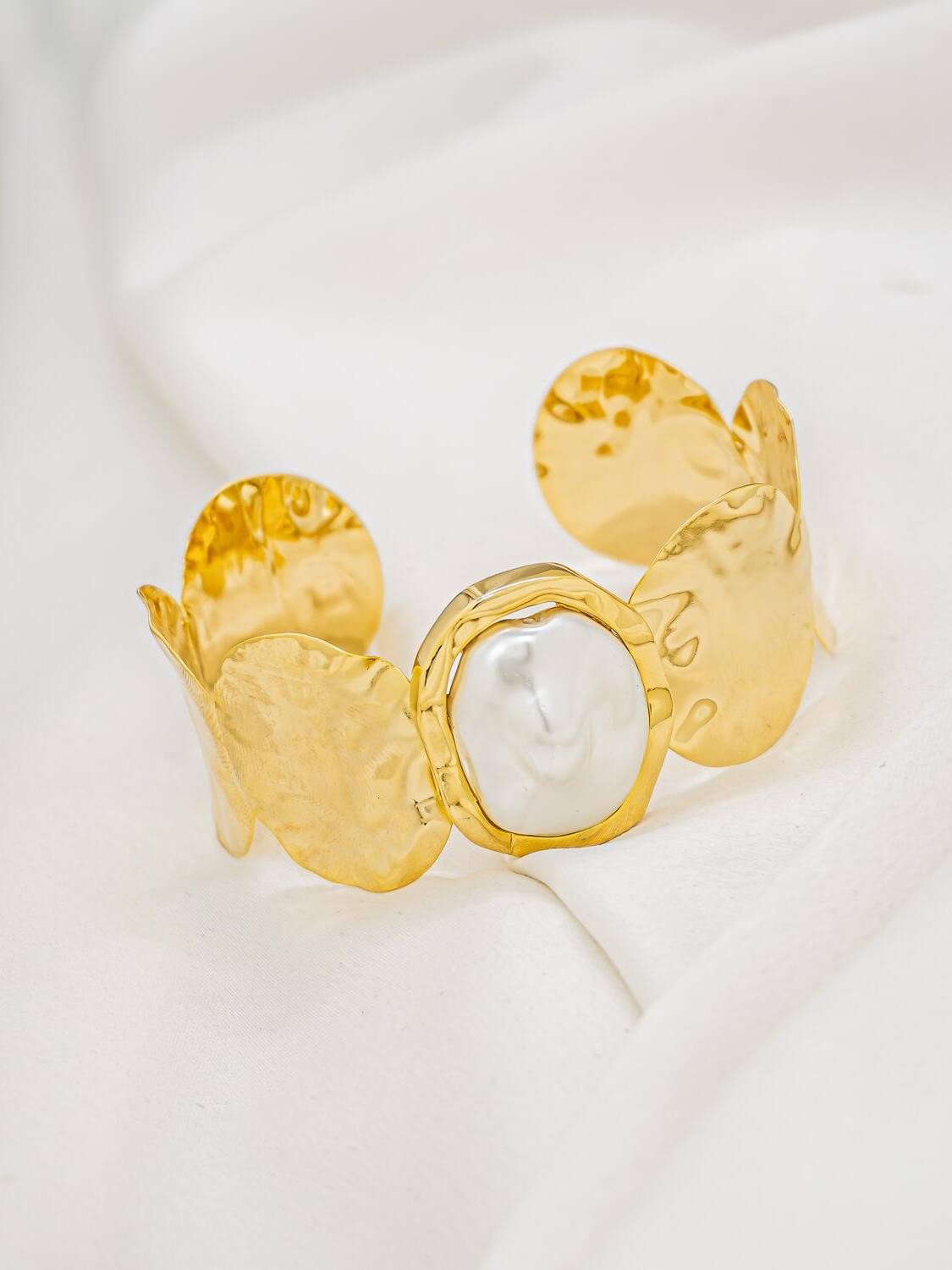 Large jonc doré martelé à disques irréguliers avec grande perle baroque blanche au centre