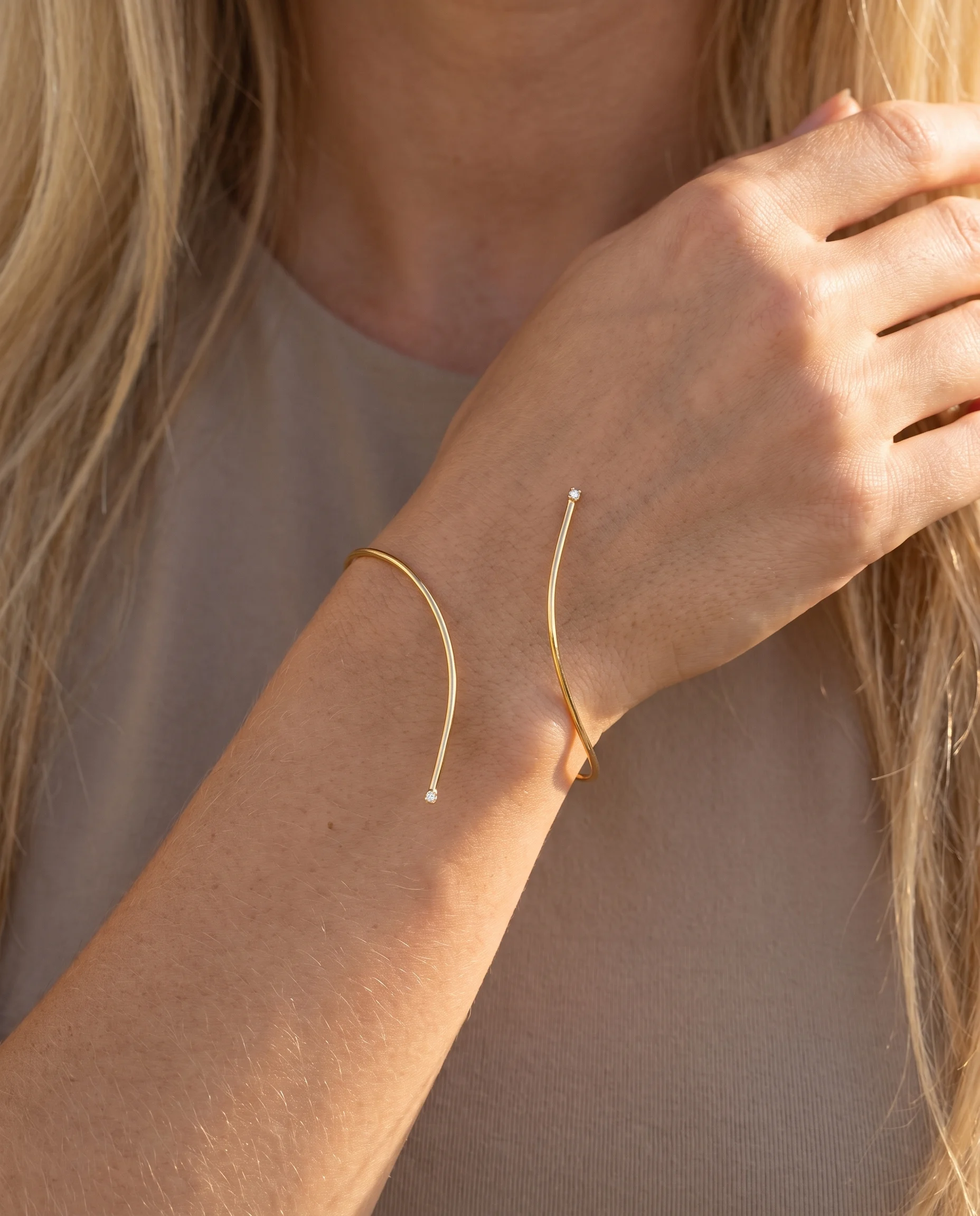 Jonc ouvert minimaliste, point de lumière aux extrémités, porté au poignet, vu de près