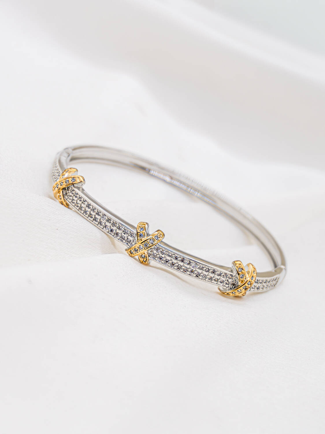 Jonc argenté pavé de petites pierres claires avec trois croisillons en X dorés