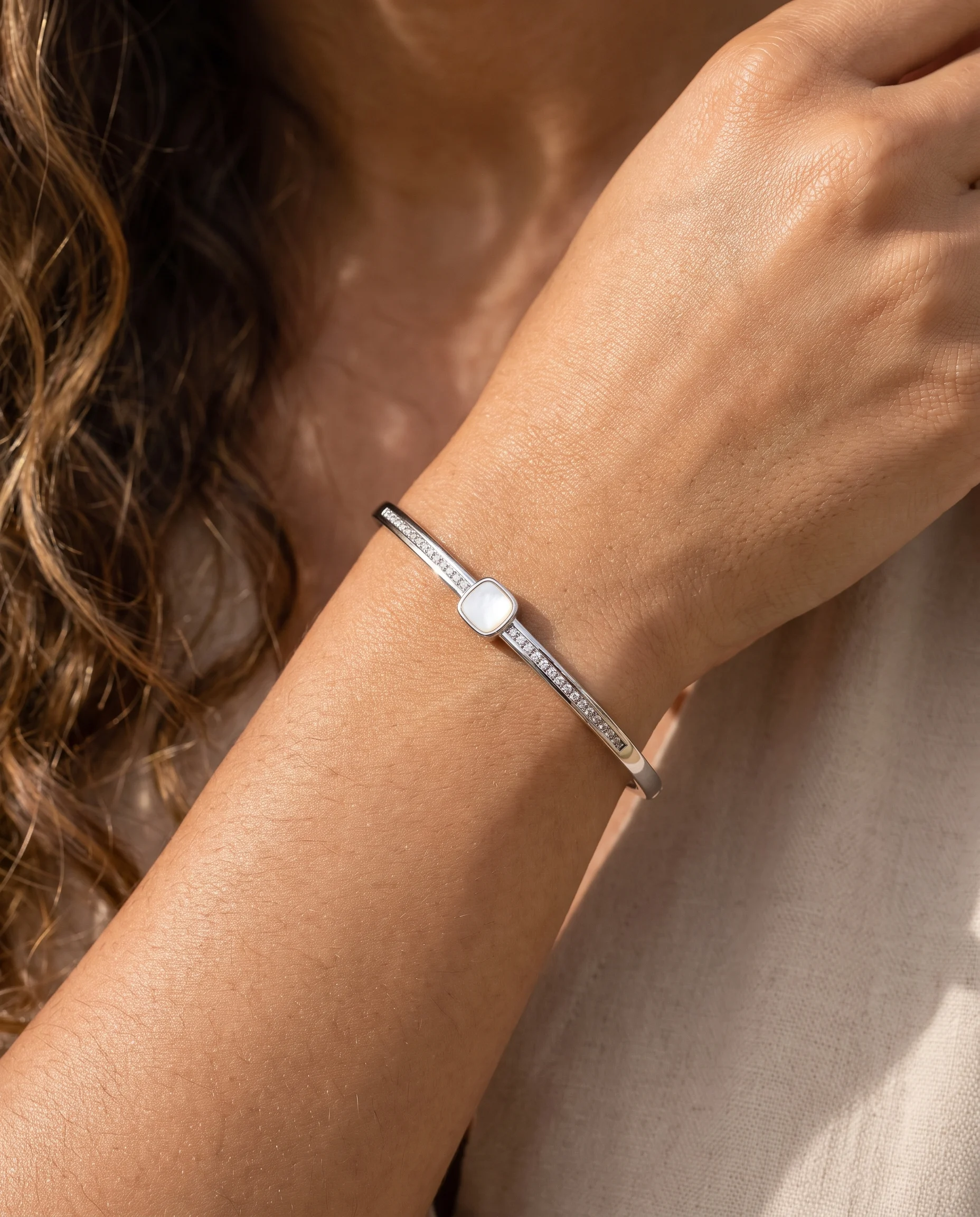Pavé-set bangle, square mother-of-pearl, white rhodium, worn on the wrist, close-up