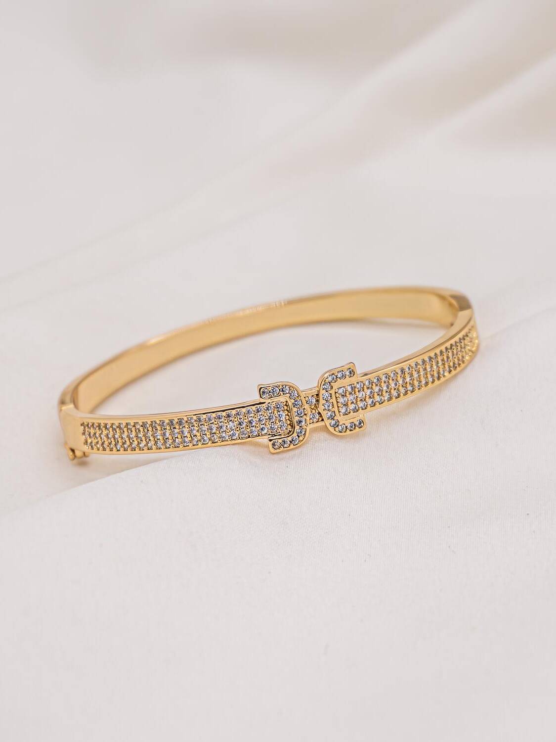 Jonc doré pavé de pierres claires avec motif central en boucle de ceinture