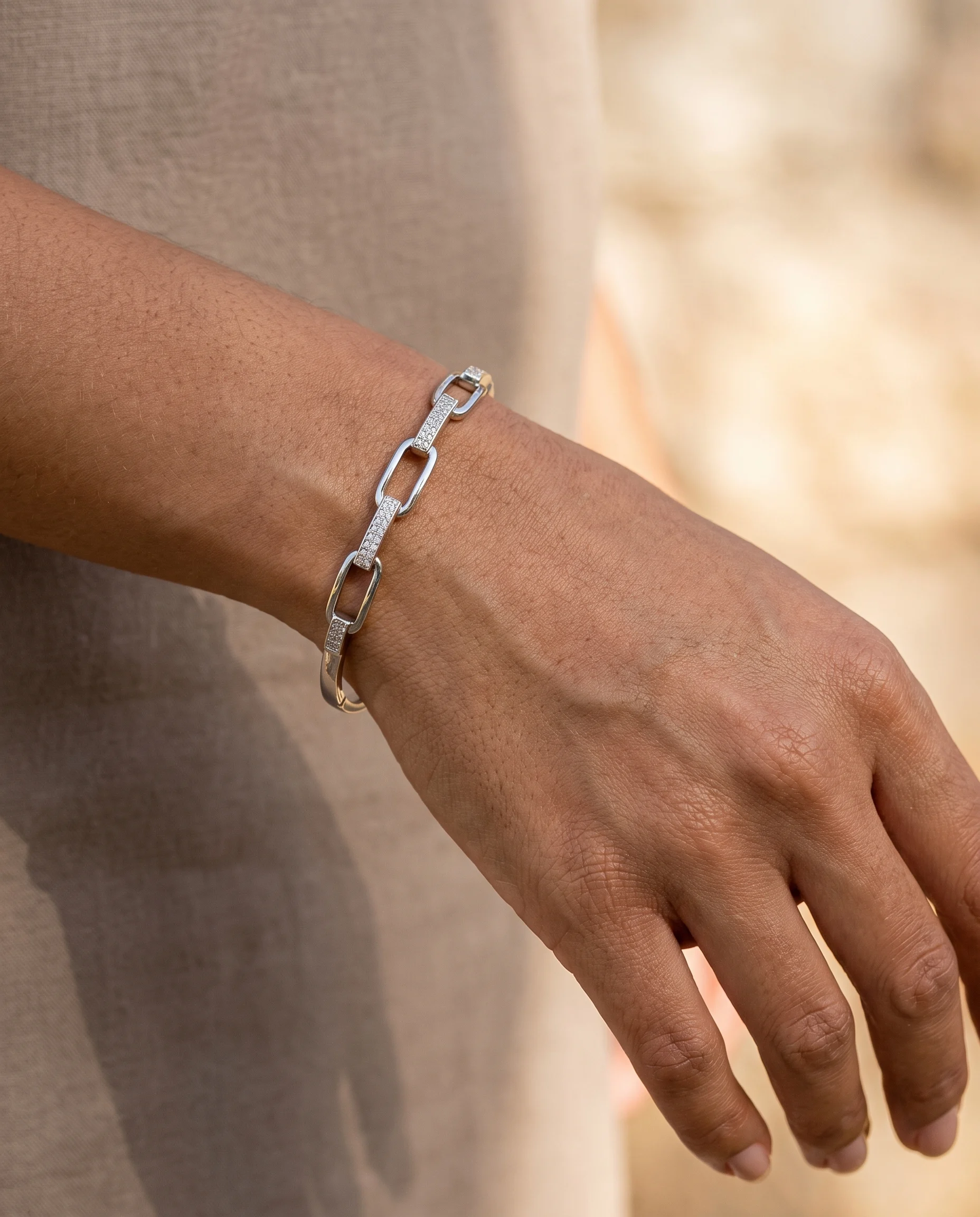 Jonc serti maillon maille ovale rhodium blanc, porté au poignet, vu de près