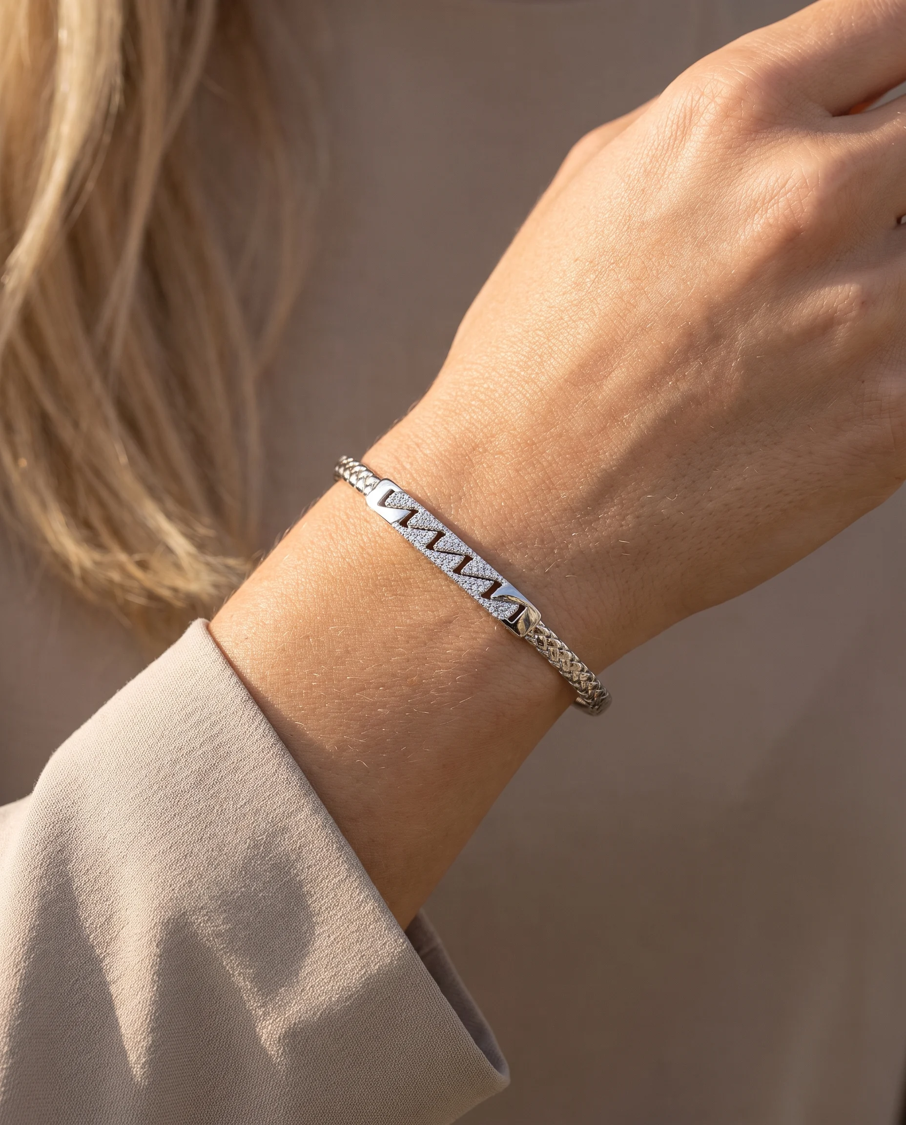 Jonc tressé serti rhodium blanc, porté au poignet, vu de près